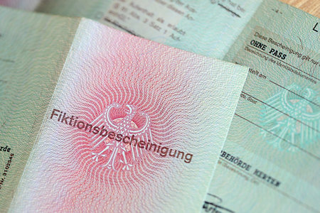 German temporary Permanent resident card specimen lies on wooden table close up. Fiktionsbescheinigungの写真素材