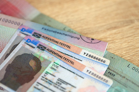 German Permanent resident card and document specimen lies on wooden table close up. Aufenthaltstitel and Fiktionsbescheinigungの写真素材