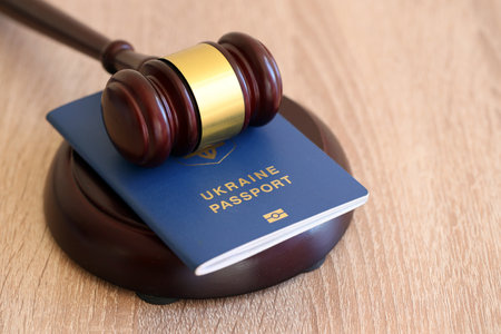 Judge mallet and ukrainian passport on brown background. Passport Of Ukraine. Obtain citizenshipの写真素材
