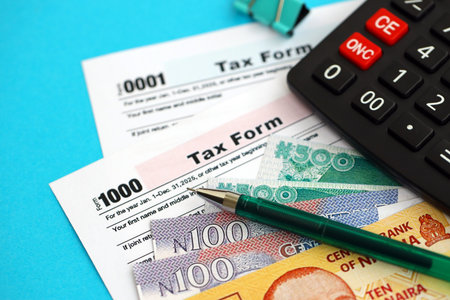Nigerian naira money bills and calculator with tax form close up. Taxation and accounting concept