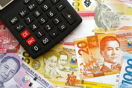 Philippines peso currency money bills and calculator close up. The concept of taxation and money countの写真素材