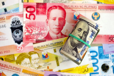 Philippines peso currency money bills and bunch of us dollar banknotes close up. The concept of economics and currency exchangeの写真素材