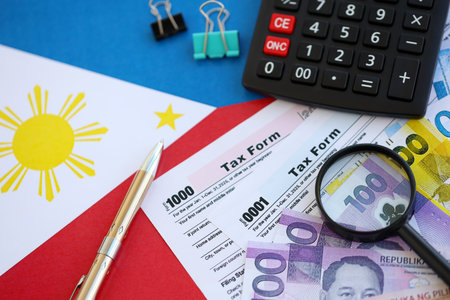 Philippines peso money bills and calculator with tax form on flag close up. Taxation and accounting conceptの写真素材
