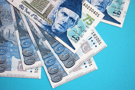 Pakistan rupees banknotes on blue background. The current Pakistan money bills lies on table in big...