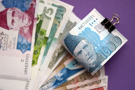 Pakistan rupees banknotes on purple background. The current Pakistan money bills lies on table in big amount. The concept of business and investment in Pakistanの写真素材