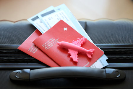 Swiss passport and avia tickets on travel bag. Pass and boarding tokens on bag close up. The concept of travel and vacation in Switzerlandの写真素材