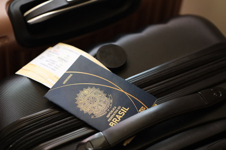 Federative Republic of Brazil passport with tickets lies on touristic suitcase close up in airport waiting hall. Travel worldwide and international tourism conceptの写真素材