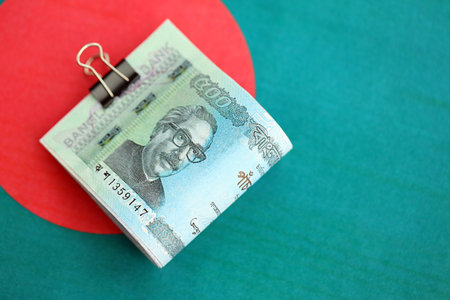Bangladeshi taka money bills in big amount lies on Bangladesh flag close up. Finance and banking conceptの写真素材