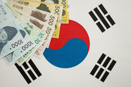 South Korean won money bills in big amount lies on South Korea flag close up. Finance and banking...