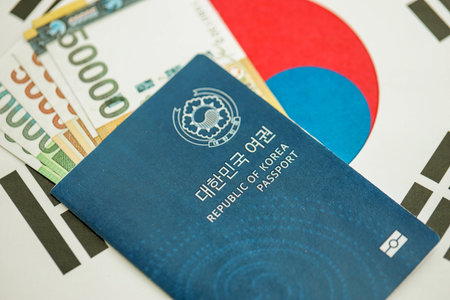 South Korean won money bills in big amount and passport lies on South Korea flag close up. Finance and banking conceptの写真素材