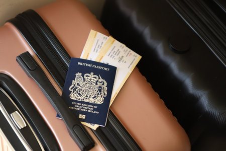 British passport with tickets lies on touristic suitcase close up in airport waiting hall. Travel...