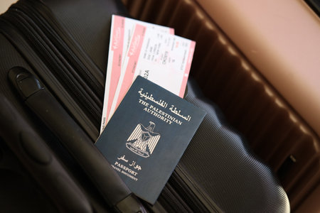 Palestinian Authority passport with tickets lies on touristic suitcase close up in airport waiting hall. Travel worldwide and international tourism conceptの写真素材