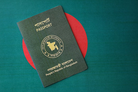 Bangladeshi passport lies on Bangladesh flag close up. Travel and citizenship conceptの写真素材
