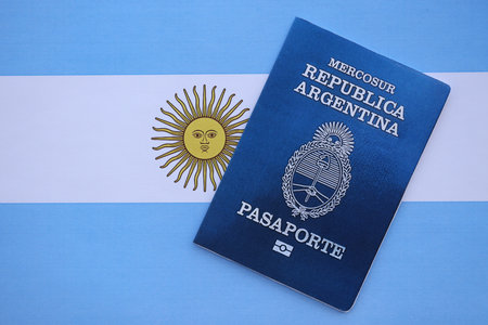 Argentine passport lies on Argentina flag close up. Travel and citizenship conceptの写真素材