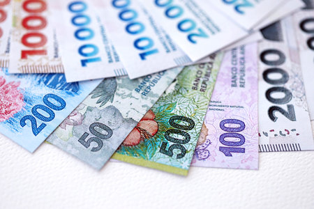 Argentine pesos money bills in big amount lies on white table close up. Finance and banking concept