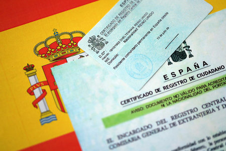 Citizenship or naturalization certificate document and card on flag of Spain close upの写真素材
