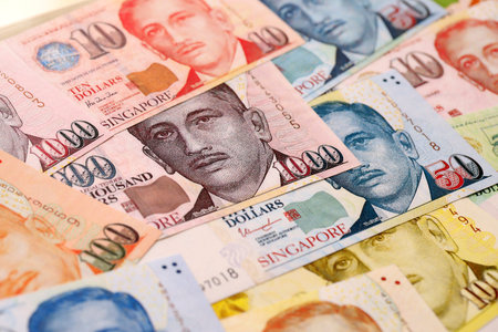 Singapore Dollar currency money bills. SGD currency banknotes in pile with different denomination...
