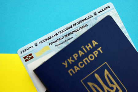 Ukrainian residence permit card or permanent resident card with passport on Ukraine flag close upの写真素材