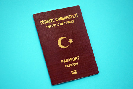 Turkish passport book on light blue paper background close up. Travel document on blue surfaceの写真素材
