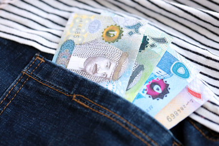 Bahraini dinar money bills in denims pocket close up.