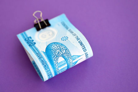 United Arab Emirates dirham money bills in big amount on purple close up. Finance and banking...