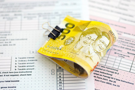 Philippines peso money bills on tax form close up. Taxation and accounting conceptの写真素材