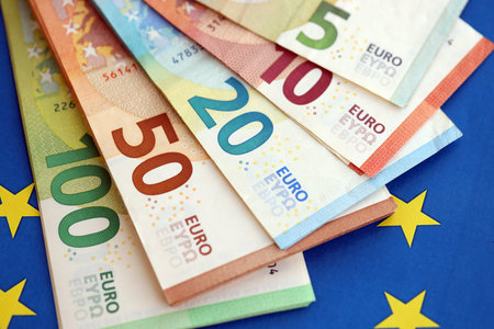 European eur currency money bills on Euro union blue flag close up. Concept of business and economics in Europeの写真素材