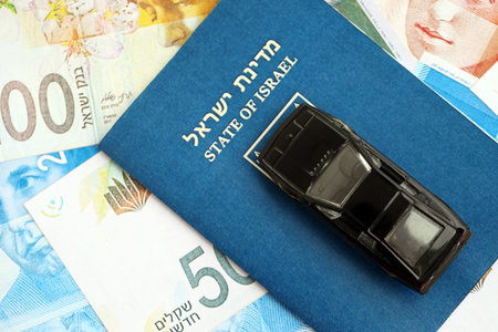 Israel New Shekels banknotes and toy car with passport. The current Israel money bills and black car with pass lies on table in big amount. The concept of car ownership in Israelの写真素材