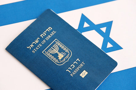 Israel passport on flag. The current Israel biometrical pass lies on flag close up. The concept of citizenship in Israelの写真素材