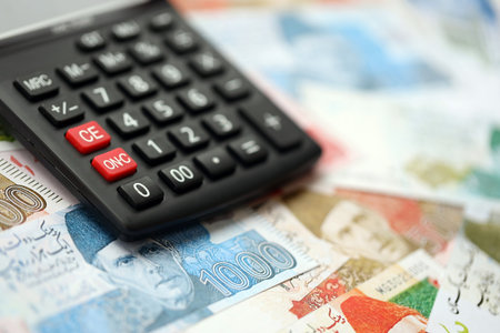 Pakistan rupees banknotes and calculator. The current Pakistan money bills and calculator lies on...