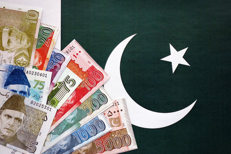 Pakistan rupees banknotes on Pakistani flag background. The current Pakistan money bills lies on banner in big amount. The concept of economics and business in Pakistanの写真素材