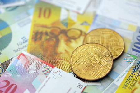 Swiss franc banknotes and bitcoin. The current francs money bills and bit coin lies on table in big amount. The concept of taxation and business in Switzerlandの写真素材