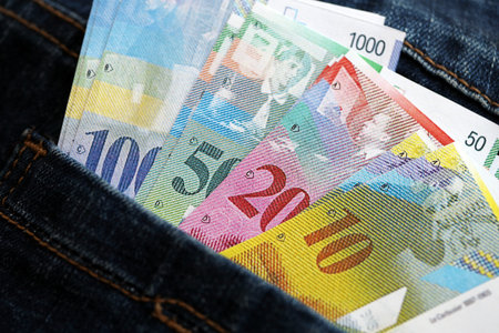 Swiss franc banknotes in denims pocket. The current francs money bills lies in jeans pocket. The concept of fashion and wealth in Switzerlandの写真素材