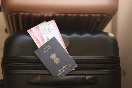 Indian passport with tickets lies on touristic suitcase close up in airport waiting hall. Travel worldwide and international tourism conceptの写真素材