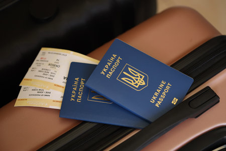 Ukrainian passports with tickets lies on touristic suitcase close up in airport waiting hall. Travel worldwide and international tourism conceptの写真素材
