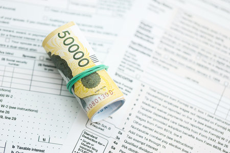 South Korean won money bills in big amount lies on table with tax forms close up. Accounting and...