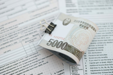 North Korean won money bills in big amount lies on table with tax forms close up. Accounting and...