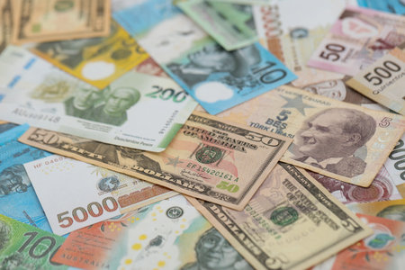 Big amount of money bills of different currencies and countries. Assortment background of international cash in big pile close upの写真素材