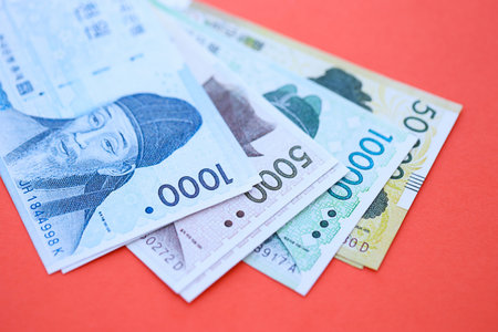 South Korean won money bills in big amount lies on red color table close up. Finance and banking conceptの写真素材