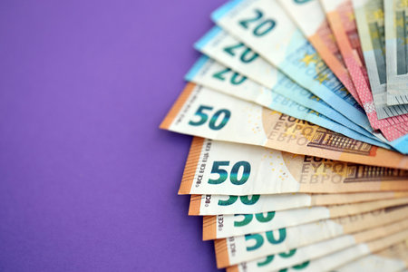Big amount of european euro currency money notes on purple color table close up. Concept of business and income in Europeの写真素材