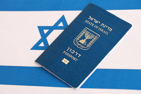 Israel passport on flag. The current Israel biometrical pass lies on flag close up. The concept of citizenship in Israelの写真素材