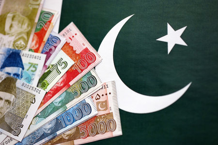 Pakistan rupees banknotes on Pakistani flag background. The current Pakistan money bills lies on banner in big amount. The concept of economics and business in Pakistanの写真素材