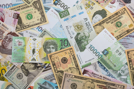 Big amount of money bills of different currencies and countries. Assortment background of international cash in big pile close upの写真素材