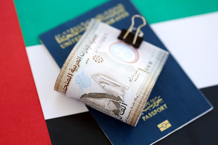 United Arab Emirates dirham currency money bills and passport lies on flag close up. The concept of travel and vacationの写真素材