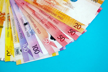 Philippines peso money bills in big amount close up on blue. Finance and banking concept
