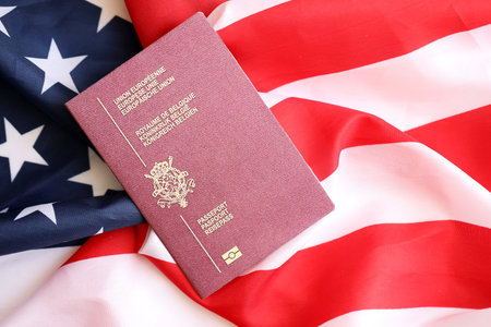 Belgium passport on big waving flag of United States of America close up. US Visa and immigration conceptの写真素材