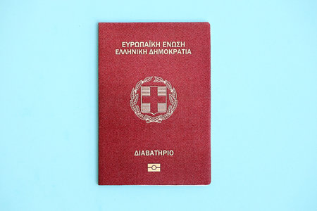 Greece passport on light blue paper background close up. Citizenship and travel in Europe conceptの写真素材