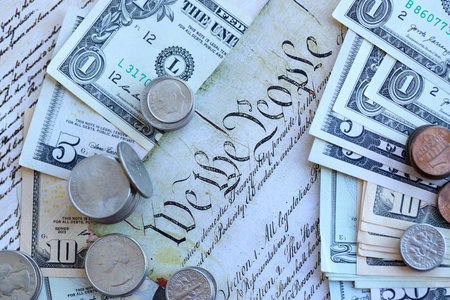 National Debt Ceiling Concept - US Constitution with different banknotes of Dollar Bills sitting above close upの写真素材