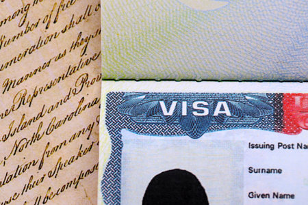 US visa stamped on a passport page with USA Constitution page background. Travel and immigration conceptの写真素材