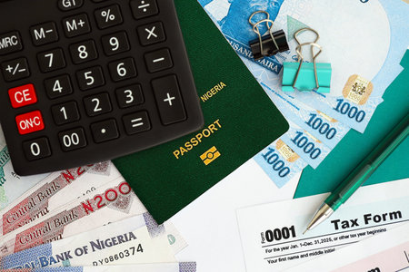 Nigerian naira money bills and calculator with tax form on flag close up. Taxation and accounting...